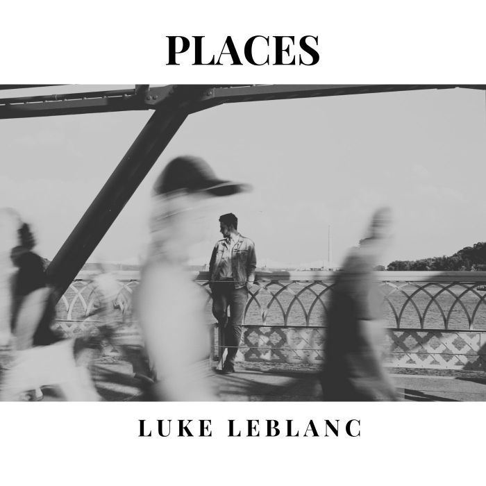 Luke LeBlanc – Places album cover. Image of a man standing along the railing of a bridge. Passersby walk in front of him but are blurred and out of focus.